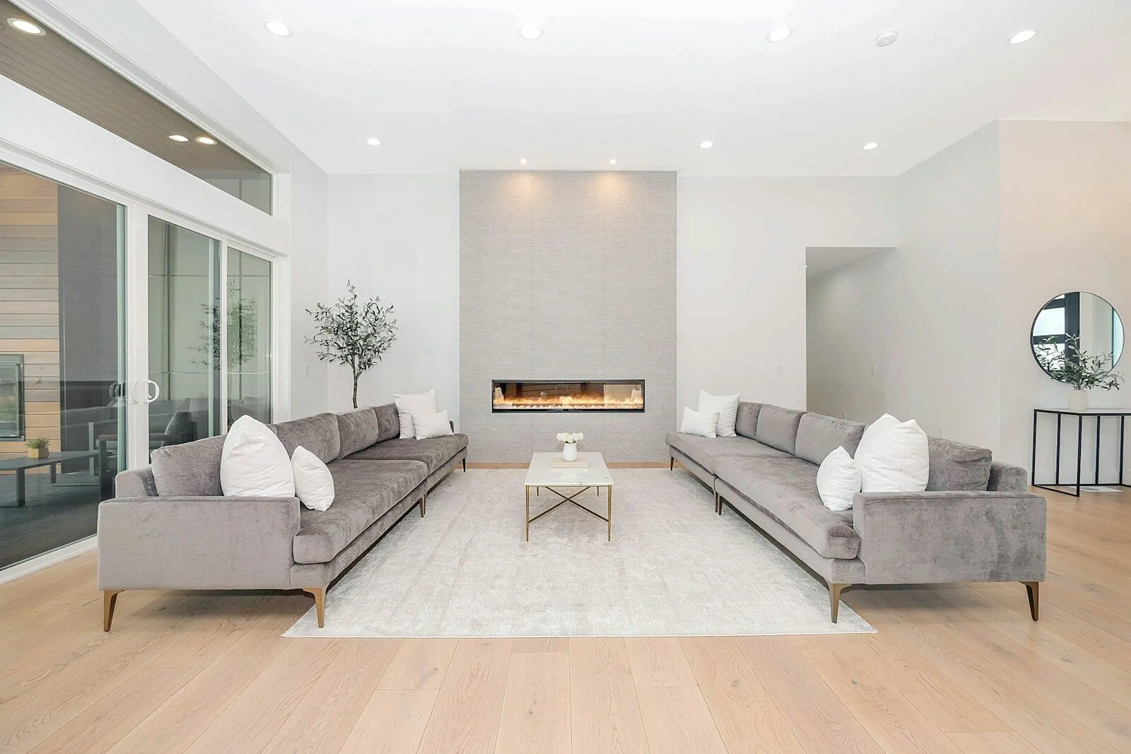 Two grey velvet sofas facing each other in a bright modern living room
