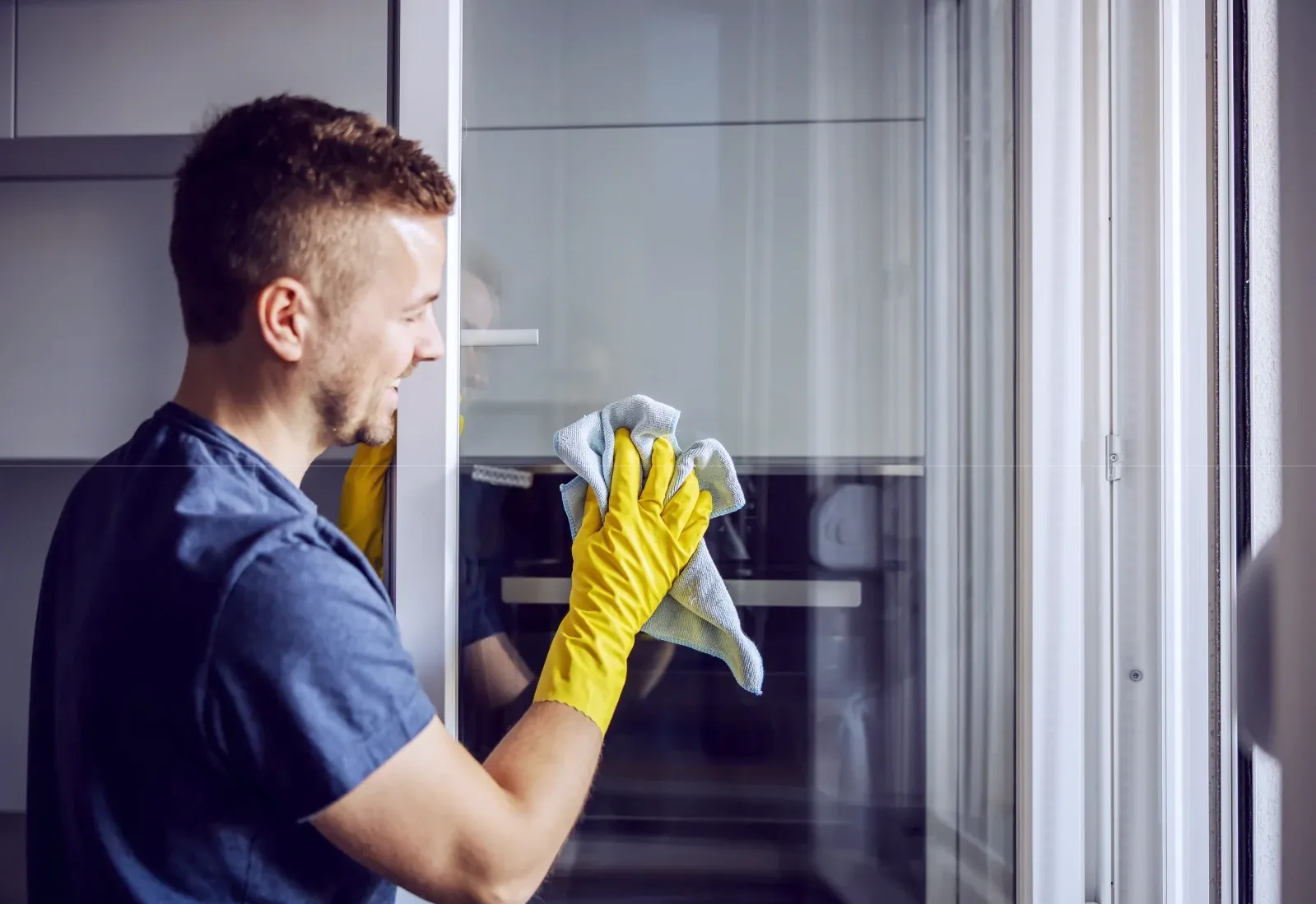Cleaner wiping a glass door in an office